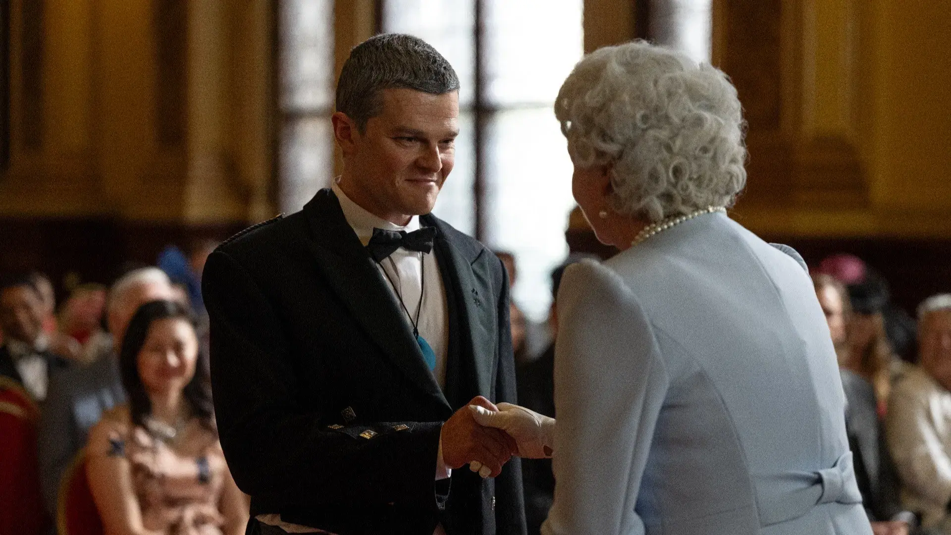 ohn Davidson (Robert Aramayo) shakes hands with Queen Elizabeth at an awards ceremony in I Swear – from the good.film film guide