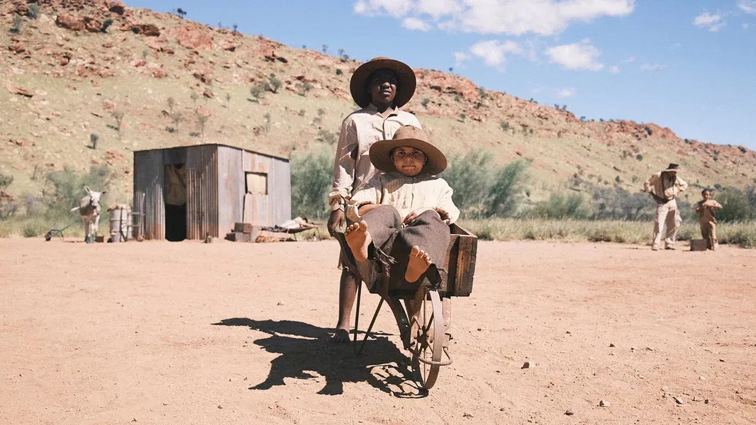 Two Aboriginal children in period costume on a dusty outback set from Warwick Thornton's film Wolfram (2026)