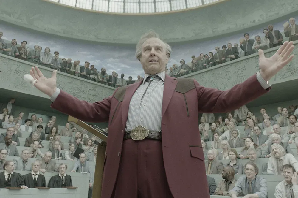 Tom Cruise as Digger as he addresses a council of visually washed-out Europeans